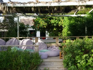 Shaded chill-out lounge with bean bags and flowering plants under a pergola at Villa Almar in Tarifa