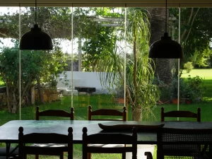 Dining table with pendant lamps and a glass wall onto the garden at Villa Almar in Tarifa