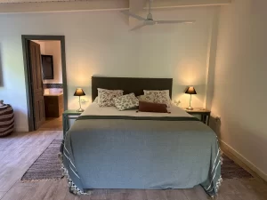 Double bedroom with grey headboard and en-suite access at Villa Almar in Tarifa