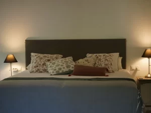 King-size bed with floral cushions and bedside lamps at Villa Almar in Tarifa