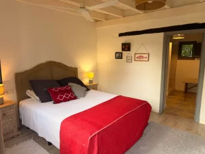 Double bedroom with cane headboard and red throw at Villa Almar in Tarifa