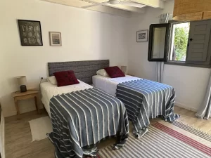 Twin bedroom with two single beds and striped throws at Villa Almar in Tarifa