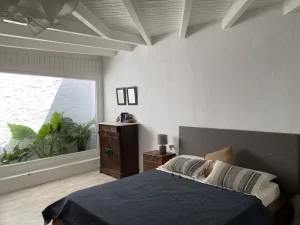 Double bedroom with a picture window onto a tropical patio at Villa Almar in Tarifa