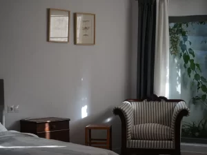 Armchair and bedside table beside a window onto the inner patio at Villa Almar in Tarifa