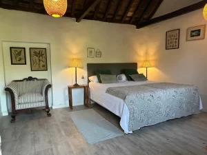 Double bedroom under exposed wooden beams with botanical prints at Villa Almar in Tarifa