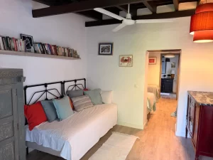 Twin room with iron bedsteads, colourful cushions and a bookshelf at Villa Almar in Tarifa