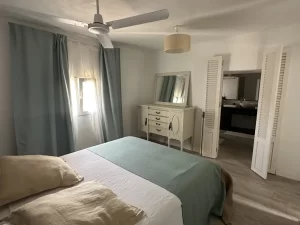 Double bedroom with ceiling fan and a vintage dressing table at Villa Almar in Tarifa