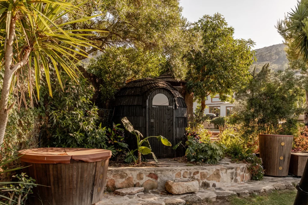 Private garden at Villa Gran Paraiso with covered wooden hot tub and thatched cabana
