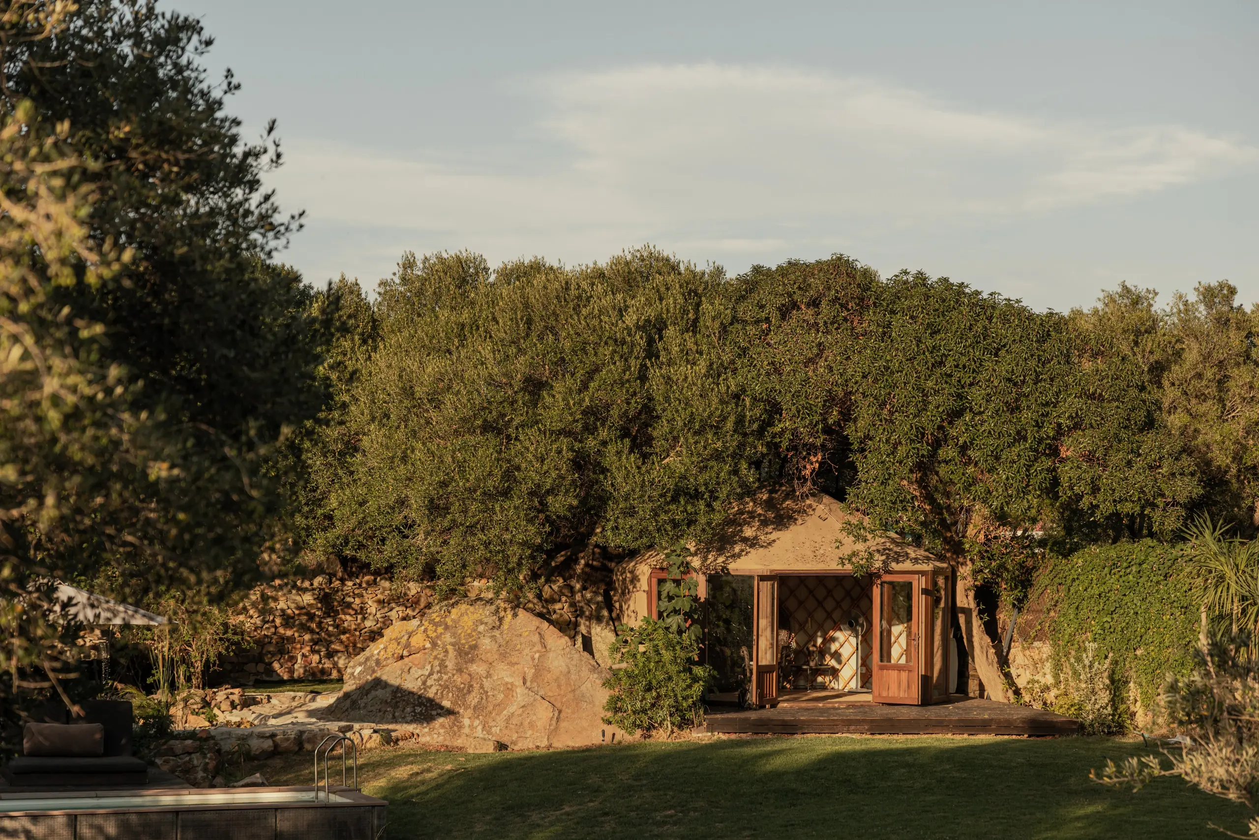 Yourte et terrasse de piscine de la Villa Gran Paraiso parmi les oliviers au coucher du soleil