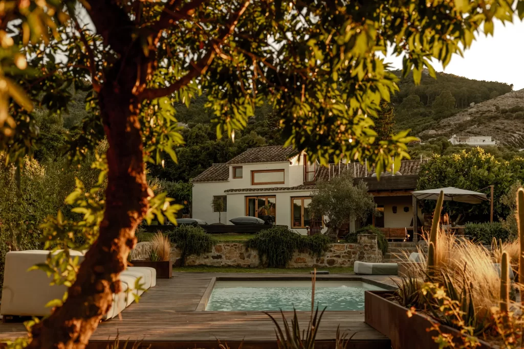 Villa Gran Paraiso exterior framed by trees with pool in foreground